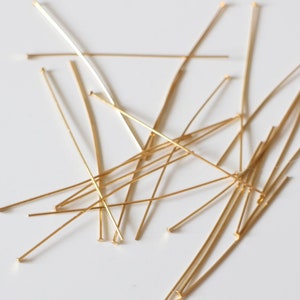 Pu&ograve; includere: Un mucchio di spilli per la testa dorati, utilizzati per la creazione di gioielli e l'artigianato.