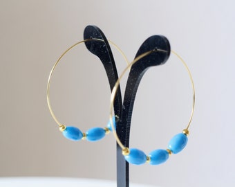 Hoop earrings in gold stainless steel and blue olive-shaped glass beads Handmade, delivered in their gift packaging free of charge