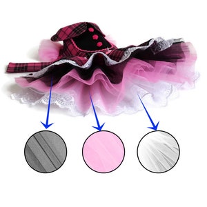 May include: A pink, black and white tulle tutu with a plaid bodice and black trim. The tutu has three layers of tulle: a black layer, a pink layer and a white layer.