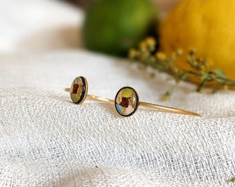 Pulseira delicada em aço banhado a ouro e contas de madeira pintadas e revestidas com resina em tons de verde-anis, azul e dourado. Uma pulseira natural e elegante.