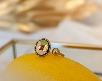Anel oval aberto com camafeu em madeira maciça de mogno pintada em verde, bege e folha de ouro. Cravação em aço inoxidável banhado a ouro.