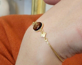 Pulseira de madeira de mogno com corrente deslizante em latão banhado a ouro. Pulseira brilhante com pingentes de concha.