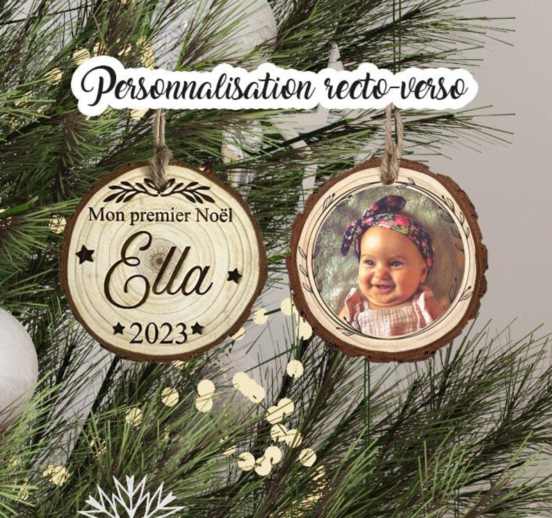 May include: Two round wooden ornaments with a rustic finish. One ornament features a photo of a baby girl wearing a headband, and the other ornament has the text "Mon premier No&euml;l Ella 2023" engraved on it.