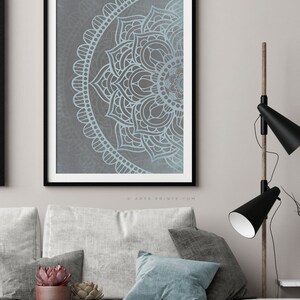 Puede incluir: Una impresi&oacute;n enmarcada de un dise&ntilde;o de mandala azul y gris. El mandala es un patr&oacute;n circular con intrincados detalles. La impresi&oacute;n est&aacute; en un marco negro y est&aacute; colgada en una pared.