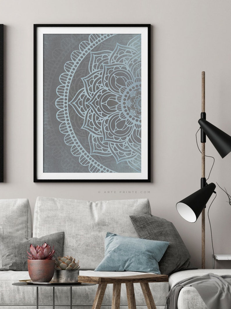 Puede incluir: Una impresi&oacute;n enmarcada de un dise&ntilde;o de mandala azul y gris. El mandala es un patr&oacute;n circular con intrincados detalles. La impresi&oacute;n est&aacute; en un marco negro y est&aacute; colgada en una pared.