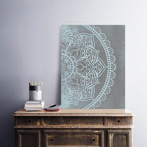 Puede incluir: Un dise&ntilde;o de mandala azul claro y gris con detalles intrincados. El mandala es un patr&oacute;n circular con un centro con forma de flor y un patr&oacute;n repetitivo de p&eacute;talos y hojas.