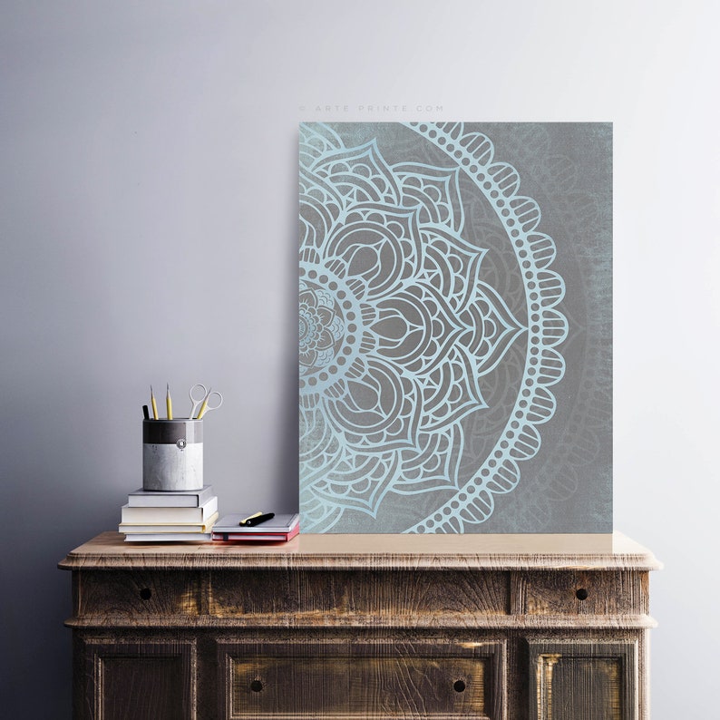 Puede incluir: Un dise&ntilde;o de mandala azul claro y gris con detalles intrincados. El mandala es un patr&oacute;n circular con un centro con forma de flor y un patr&oacute;n repetitivo de p&eacute;talos y hojas.
