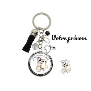 Peut inclure: Un porte-clés argenté avec un pompon noir, un charme stéthoscope et un charme rond avec une image de dessin animé d'une femme en uniforme d'infirmière. Le charme dit "Je soigne avec le coeur" et "Celine".