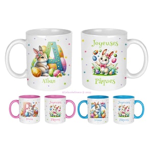 Peut inclure: Ensemble de quatre tasses en céramique blanche avec des motifs de lapin de Pâques colorés. Deux tasses présentent un lapin tenant un œuf avec le texte "Joyeuses Pâques" et deux tasses présentent un lapin avec la lettre "A" et le nom "Alban".