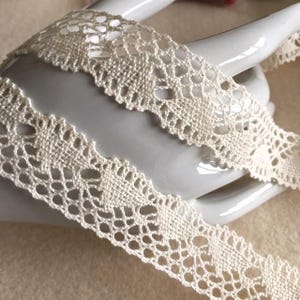 Dentelle en coton du Puy, 2.5 cm de large, de couleur écru clair, les dessins forment des coquille, Made in France, vendue au mètre