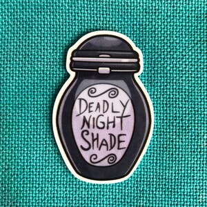 May include: A black and white sticker of a potion bottle with the text "Deadly Night Shade" on it.