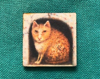 May include: A square wooden tile featuring a detailed illustration of a ginger cat. The cat is depicted in a dark, arched space, with its fur rendered in shades of orange and brown. The tile has a slightly distressed, vintage appearance.