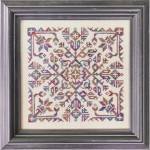 May include: Framed cross-stitch artwork featuring a symmetrical, geometric design in shades of purple, brown, and blue on a cream background. The artwork is enclosed in a dark gray wooden frame, creating a classic and decorative piece.