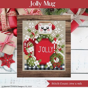 May include: Cross stitch pattern featuring a red mug with a white bear wearing a green scarf and earmuffs. The mug has the word "JOLLY!" on it and is surrounded by green holly and white flowers. The pattern is 39 stitches wide by 46 stitches high.