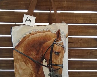 Zachte stoffen tas met schouderband. op de voorkant karamel paardenhoofd