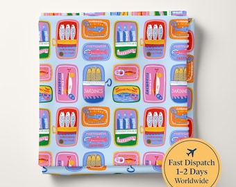 May include: A light blue fabric featuring a repeating pattern of colorful sardine and anchovy tins. The illustrations include various fish, open cans, and text labels such as Sardines, Sardinhas, and Anchovies in vibrant red, yellow, and green tones.