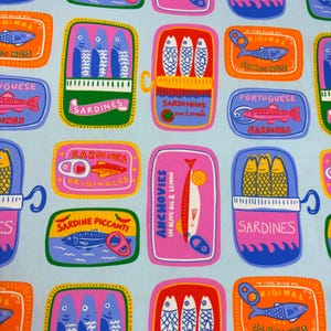 May include: A repeating pattern of colorful sardine and anchovy tins on a light blue background. The tins feature illustrations of fish and text in various languages, including "Sardines" and "Anchovies". The design is vibrant and playful.