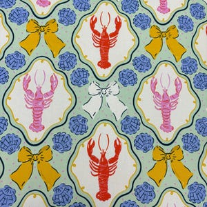 May include: A repeating pattern featuring red and pink lobsters, yellow bows, white bows, and blue seashells on a light green background. The design is framed by a decorative border, creating a whimsical and nautical theme.