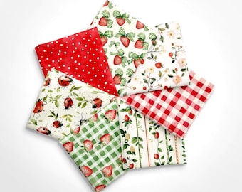 May include: A collection of folded fabric squares with various patterns. Designs include red polka dots, strawberries with bows, ladybugs, floral arrangements, red gingham, and strawberry vines. The fabrics are arranged in a circular pattern.