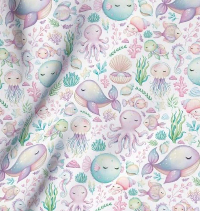 K&ouml;nnte beinhalten: Ein nahtloses Muster mit verschiedenen Meeresbewohnern in Pastellfarben, darunter Wale, Quallen, Kraken, Seepferdchen und Fische. Der Hintergrund ist wei&szlig; mit einem Aquarelleffekt.