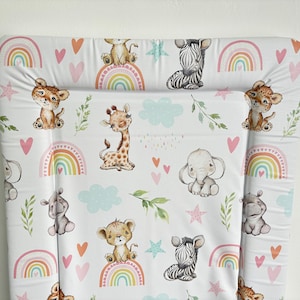 May include: White changing mat cover with a colourful animal print. The print features giraffes, zebras, elephants, hippos, and lions. The background is white with pink hearts and rainbows.