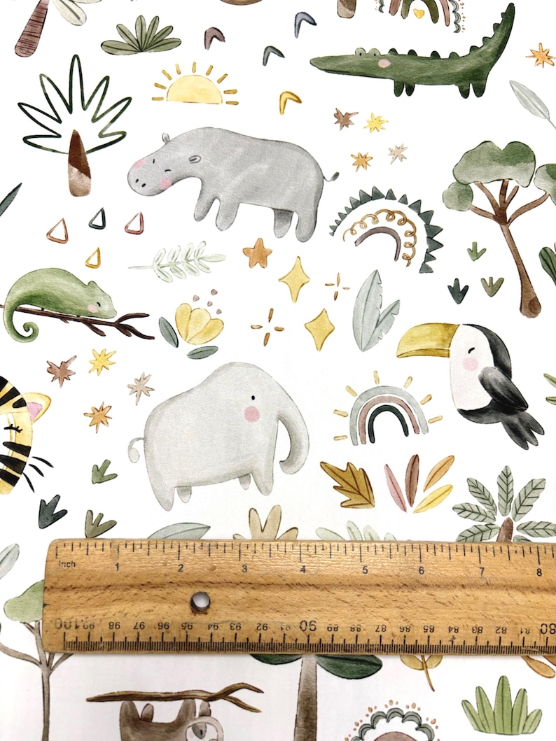May include: Watercolor pattern featuring jungle animals like a hippo, elephant, toucan, and crocodile, along with rainbows, stars, and suns. The design includes a ruler showing inches. The overall theme is a whimsical safari.