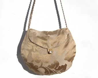 Small evening bag in gold colored fabric.