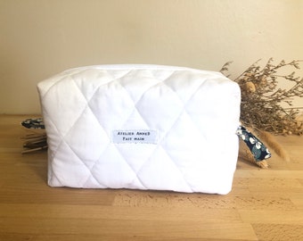 White quilted toiletry bag in oeko tex cotton lined with blue and white floral cotton with a hint of pink