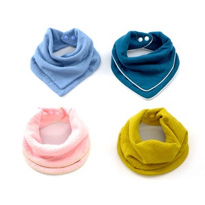 May include: Four baby bibs in different colours: light blue, teal, pink, and yellow. Each bib has a white trim and two snap buttons.
