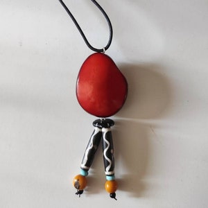 Collar elaborado con semillas de tagua o marfil vegetal de naranja, cuentas de hueso y algodón encerado.