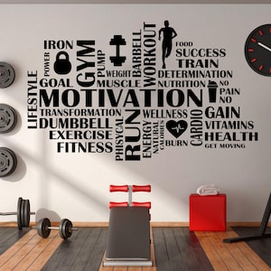 May include: A motivational fitness-themed wall art with the words "Motivation", "Fitness", and other related terms in black. A weight bench, dumbbells, and a red box are in the foreground. A black clock is on the wall.