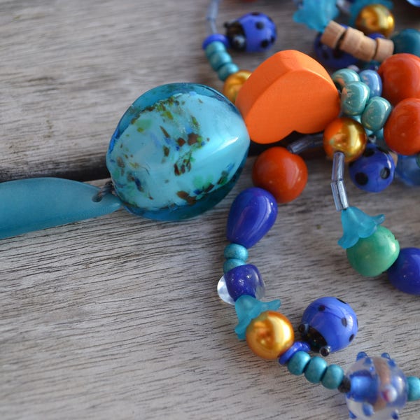 Sautoir ethnique fête des mères "En orange de coccinelles " avec tranche de tagua, perle Lampwork, perles coccinelles en verre filé, graines