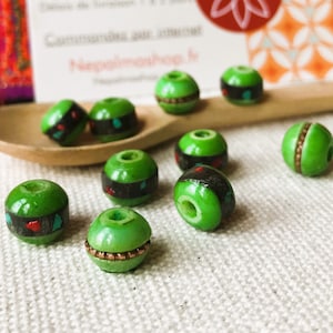 May include: A collection of ten green wooden beads with various patterns and designs. Some beads have a gold trim, while others have black and red accents.
