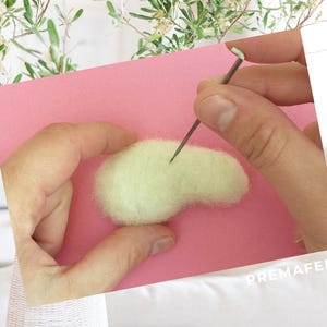 The picture shows the process of making a figure out of wool with needle felting