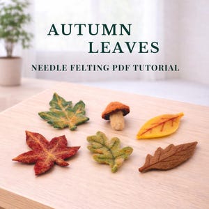 Puede incluir: Un surtido de hojas de otoño afieltradas y una seta dispuestas sobre una superficie de madera. Las hojas son de varios colores, incluyendo verde, amarillo y rojo. El texto "AUTUMN LEAVES" y "NEEDLE FELTING PDF TUTORIAL" se muestran.