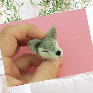 The picture shows the process of making a figure out of wool with needle felting