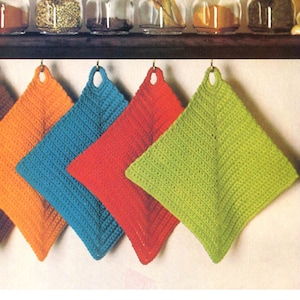 May include: Six brightly coloured, square crochet potholders hanging on hooks. The potholders are in shades of brown, orange, blue, red, and green. Each has a loop for hanging. Jars of spices are visible in the background.