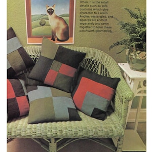 May include: A collection of patchwork cushions in various colors, including red, black, green, and blue, are arranged on a light green wicker sofa. A framed painting of a cat hangs on the wall. The text on the wall reads: "Often, it is the small details such as sofa cushions which give character tu a room."