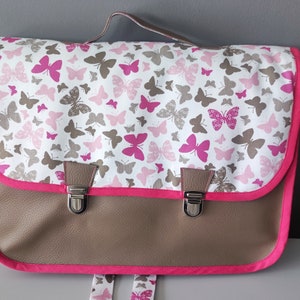 Cartable maternelle (34cm x24 cm), simili cuir taupe et tissu papillons avec  porte- étiquette, bretelles réglables.