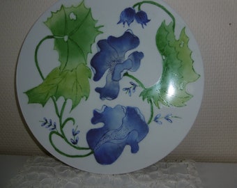 Round hand-painted porcelain cake dish decorated with two blue peonies with foliage