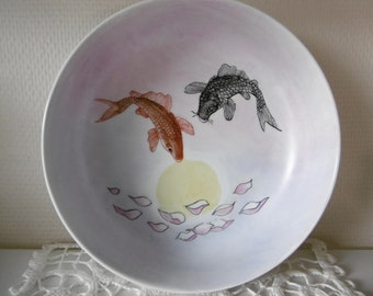 Hand-painted porcelain bowl decorated with two summer fish and a sun on a pink background of Japanese inspiration