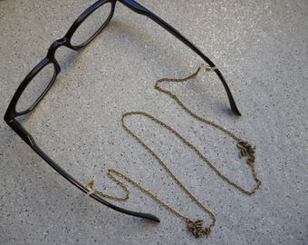 Necklace close to glasses embellished with pretty little dragons