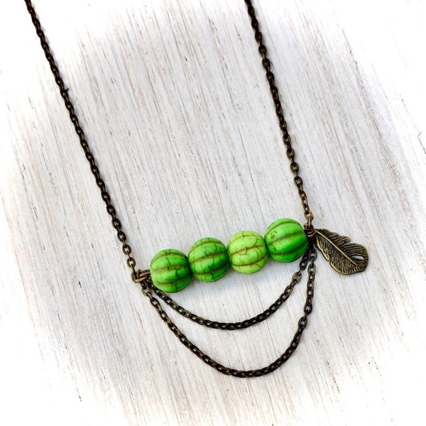 Collier chaîne en métal bronze avec pendentif barre de perles citrouilles vert anis et pendentif plume pour femme