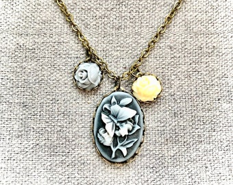 Collier chaine en métal couleur bronze avec pendentif cabochon ovale avec camée fleurs gris et petits cabochons fleurs écru pour femme