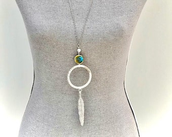 Collier Sautoir chaine en acier argenté avec grand anneau martelé, perle artisanale ronde en céramique turquoise et grande plume pour femme