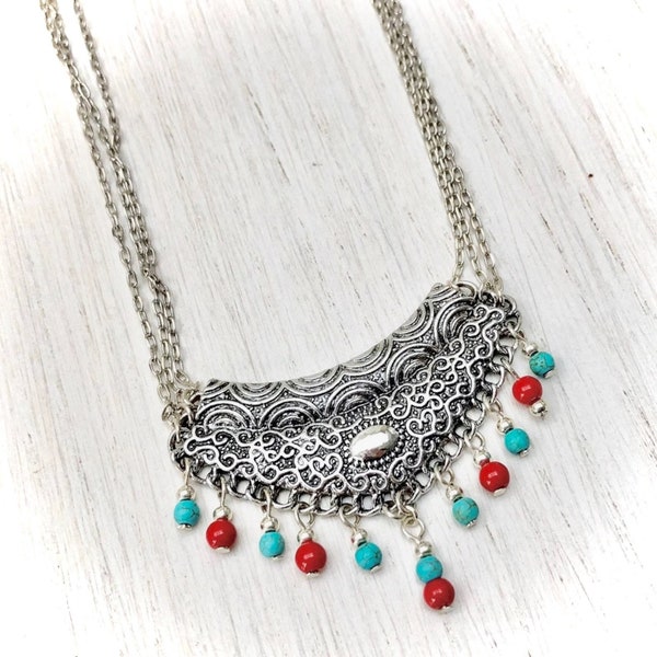 Collier ethnique chaine métal argenté avec plastron argenté et cascade de perles en céramique rouge et turquoise pour femme