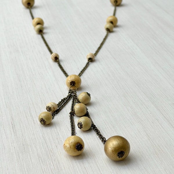 Collier sautoir chaine en métal couleur bronze avec différentes perles en bois beige et doré pour femme