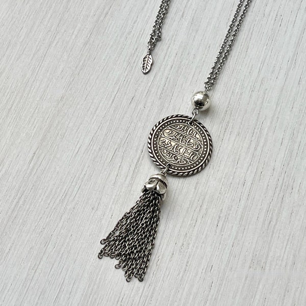 Collier sautoir style oriental en acier inoxydable argenté avec médaillon à écritures orientales et pompon argenté vieilli pour femme