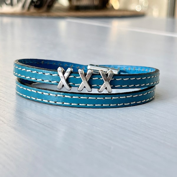 Bracelet manchette double lanière de cuir bleu turquoise surpiqué fil blanc avec 3 breloques croix X et fermoir aimanté pour femme