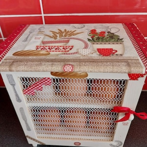 Peut inclure: Un porte-œufs décoratif en bois avec une façade en treillis métallique. Le dessus présente un motif imprimé avec du pain, du blé et une théière. Orné d'un ruban rouge et des mots "Fresh Milk".